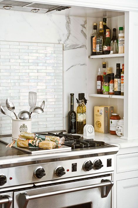 a modern farmhouse white kitchen with a niche with shelves that are used for storing oils and sauces that are necessary for cooking