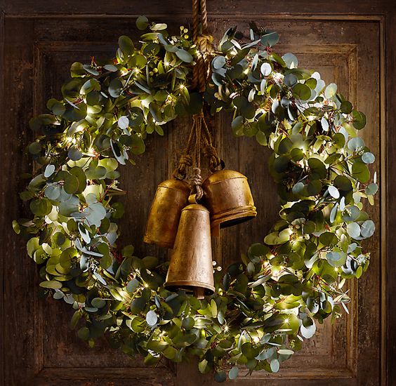 A beautiful vintage style green wreath with lights and large vintage bells is a stylish Christmas decoration