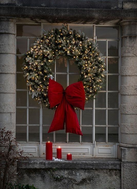 A flocked Christmas wreath with a large red bow is a cool and eye-catching decoration for the holidays