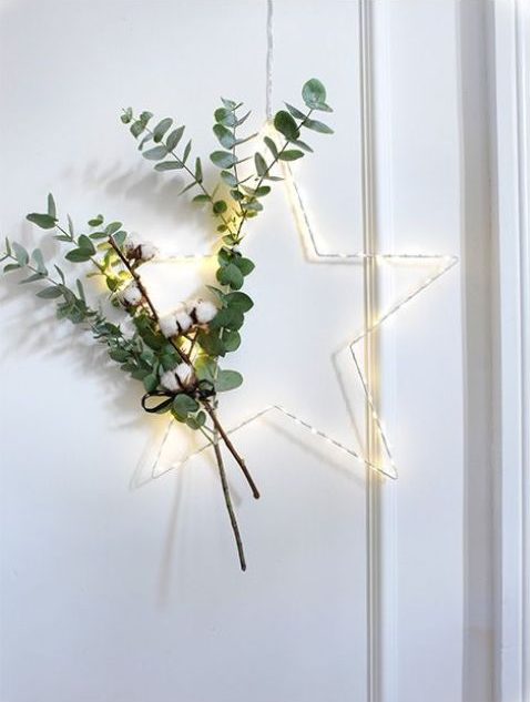 A lighted Christmas wreath with cotton and eucalyptus is a beautiful decoration idea for a Scandinavian or modern room