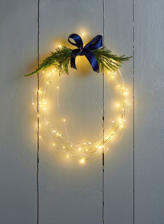 A bright wreath with lots of greenery and a navy blue bow on top is a cool and cute Christmas decoration