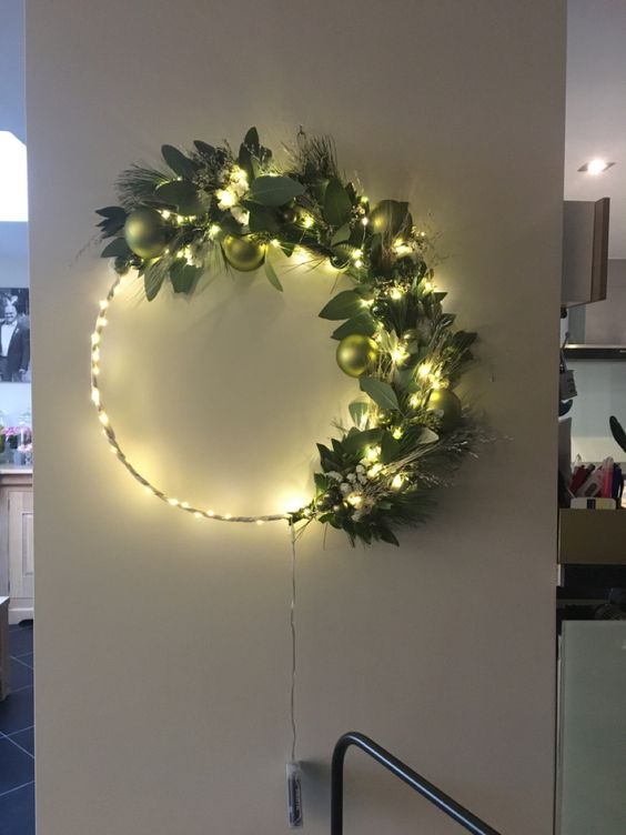 A modern Christmas wreath with lights, greenery and bright green ornaments is a beautiful decoration