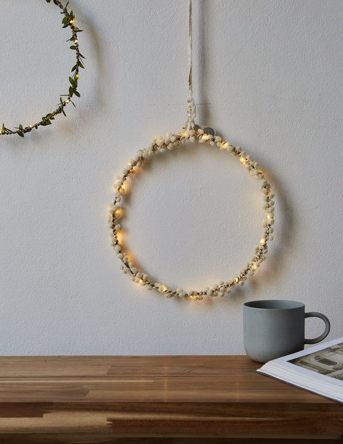 A pretty Christmas wreath made of lights and white berries is a delicate and cool decoration for the holidays