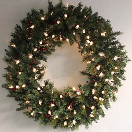A stylish evergreen holiday wreath with red berries and lights is a catchy but laconic decoration