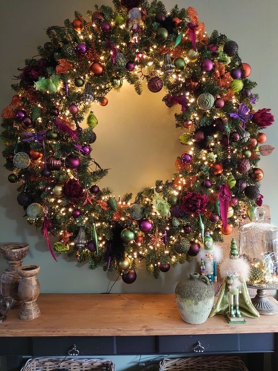 A super bold holiday wreath made with evergreens and all sorts of colorful ornaments and lights and ribbons is wow