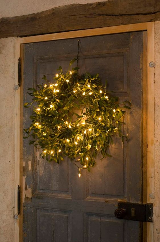 A textured green Christmas wreath with lights is a stylish, modern farmhouse decoration for the holidays