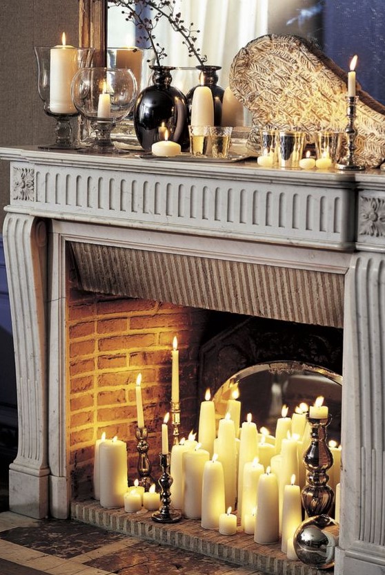 a vintage fireplace with a pillar and tall and thin candles and with vintage candle holders in it