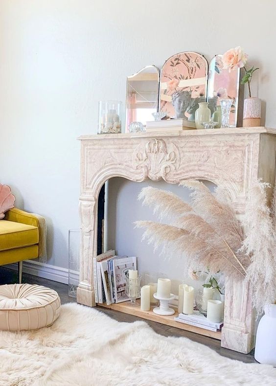 A vintage French mantel with pillar candles, books, a mirror, and some more pastel decor is a cool idea for a delicate space