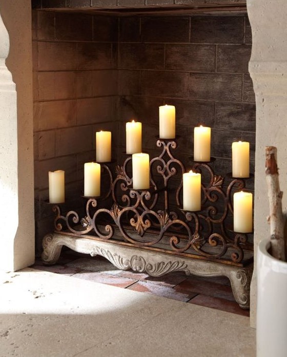 A forged candlestick with vignettes right in the fireplace is a clever idea to try
