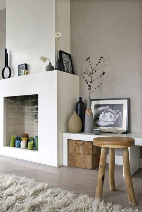 A modern non-working fireplace with colorful candles inside looks eye-catching and fun, matching the style of the room