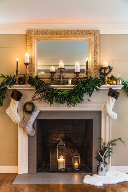 a non-working winter style fireplace with dark bricks and candle lanterns inside and candles on the mantel