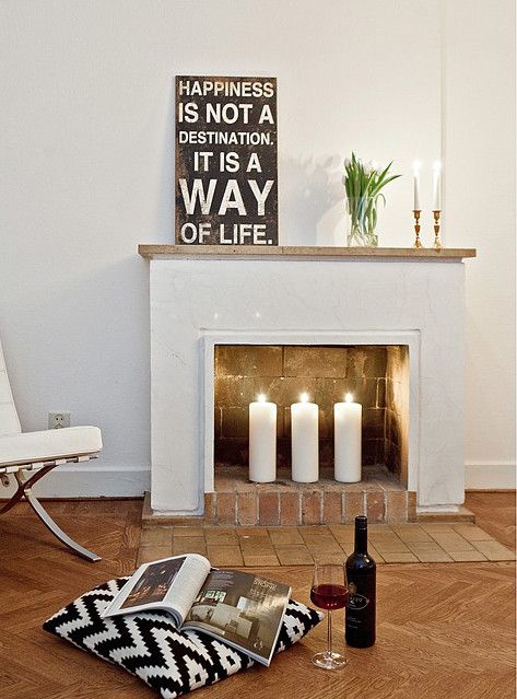 a non-functioning fireplace with bricks inside and out and pillar candles for proper decor
