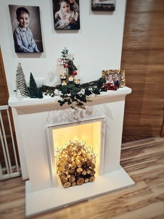 A fake fireplace with logs and lights on it, some Christmas decorations on the mantel is wonderful for making a room cozier