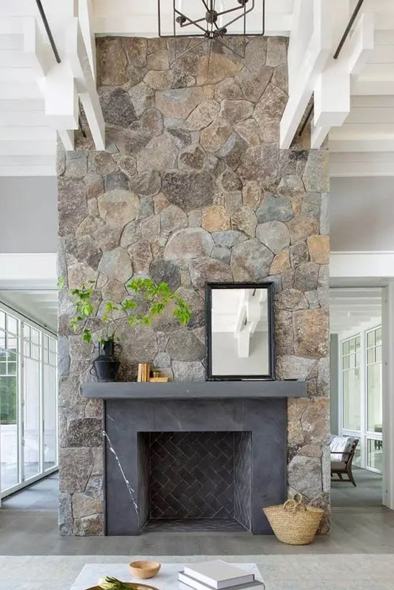 A large fireplace clad in beautiful stone and decorated with greenery will be an eye-catcher in your room