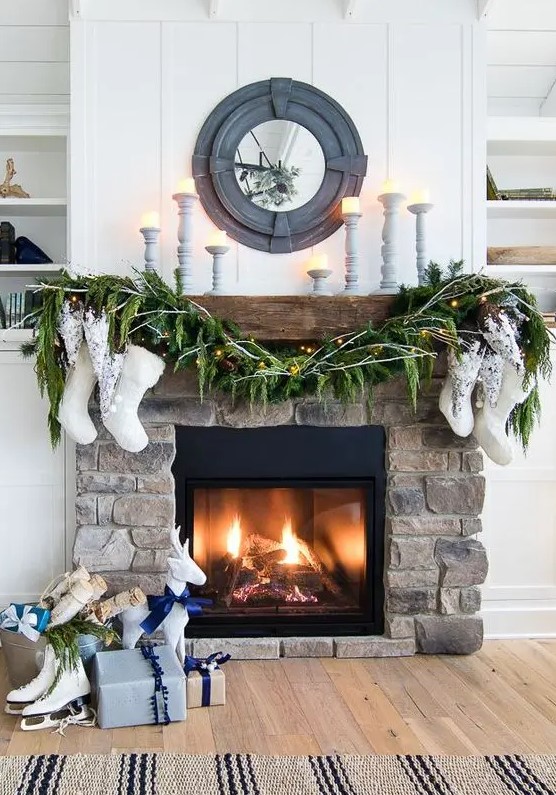 A stylish stone-lined fireplace decorated with evergreens, stockings and a few candles looks great in a farmhouse