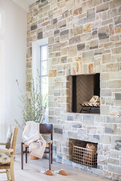 A whole wall covered in stone with a built-in fireplace is a cool solution for a rustic home, adding texture and interest to the room