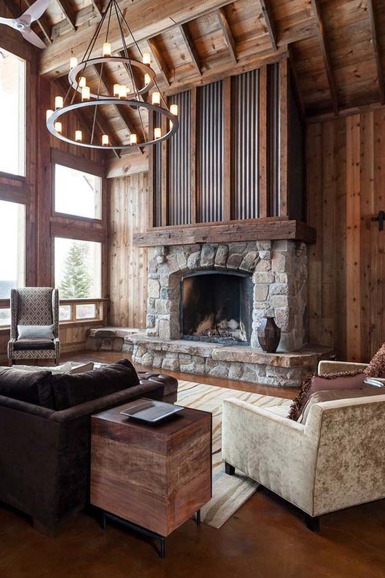 an elegant and chic cottage living room with richly stained wood, a stone and metal fireplace and vintage furnishings