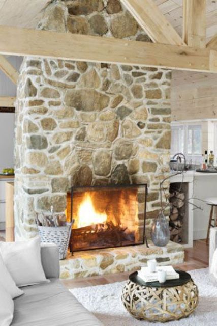 A large stone fireplace separates the kitchen from the living room, making both cozier and warmer