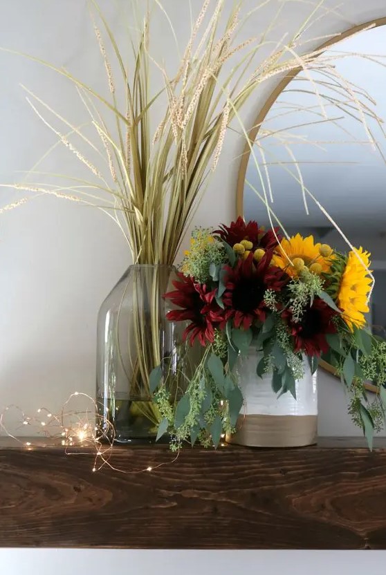 A chic artificial flower arrangement for autumn with lots of eucalyptus, burgundy and yellow flowers as well as a grass arrangement
