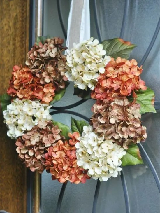 A vintage-inspired artificial hydrangea wreath in brown, rust and white on a silk ribbon is a very stylish decoration idea