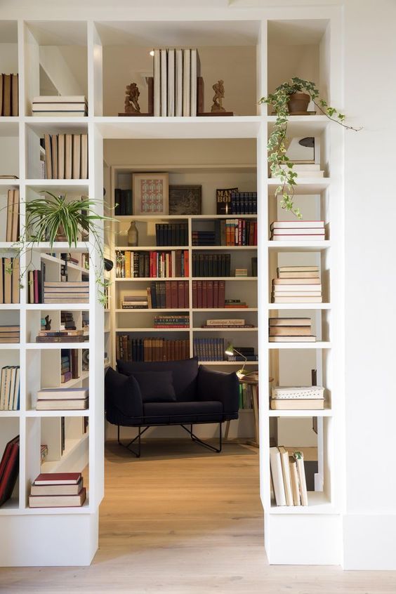 A door with built-in bookshelves that double as a room divider and provide plenty of storage space for books