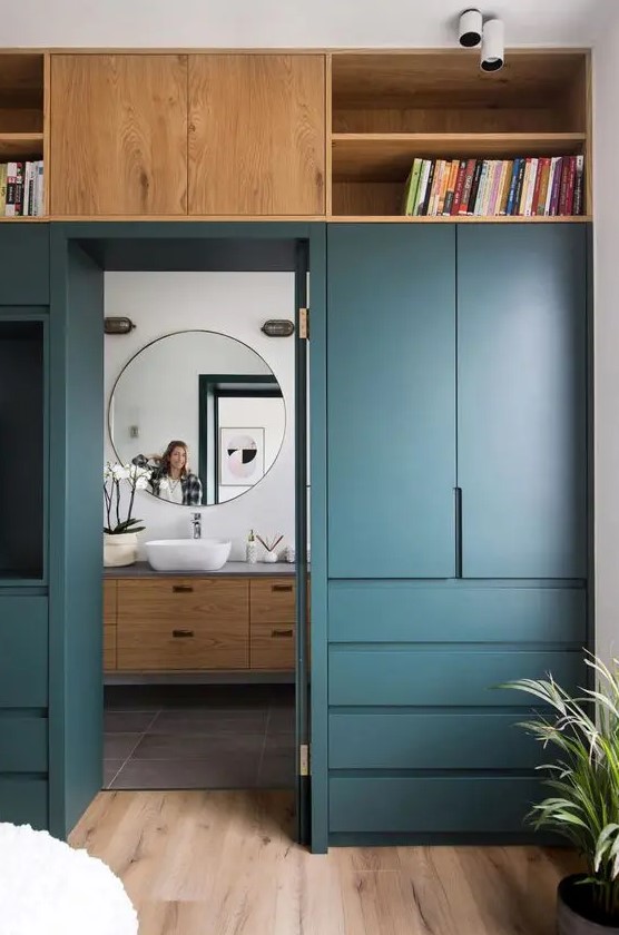 A door wall with elegant cabinets and drawers and open shelves allow you to store a lot of things without cluttering up the bedroom