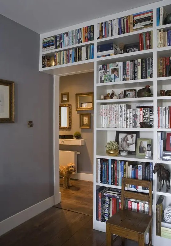 A door wall covered with open shelves with lots of books is a cool idea to organize your home library without wasting a lot of space