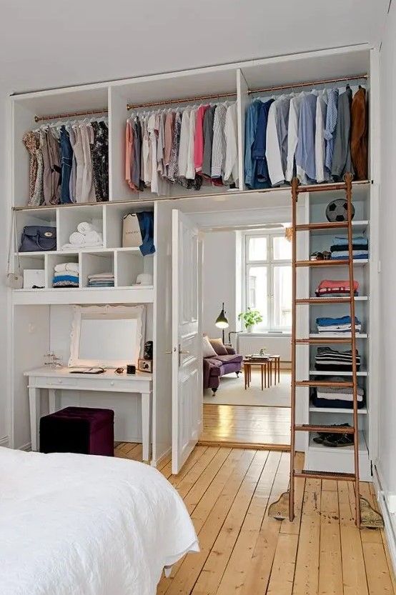 a small bedroom with railing and open storage shelves over the door forming a closet to save space
