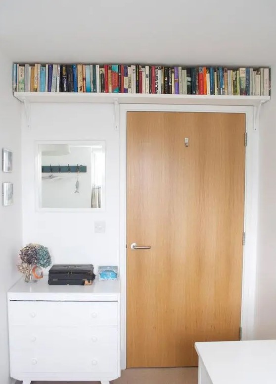 A small bookshelf above the door allows you to store a lot of books while not cluttering up the small space