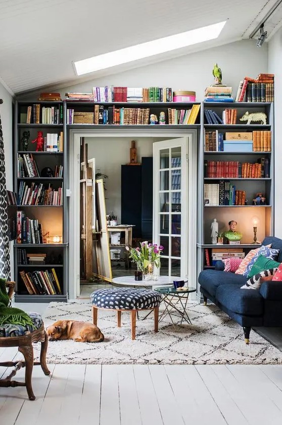 A small living room with open shelves that take up an entire wall including the door - a clever idea that allows you to store a lot of things here