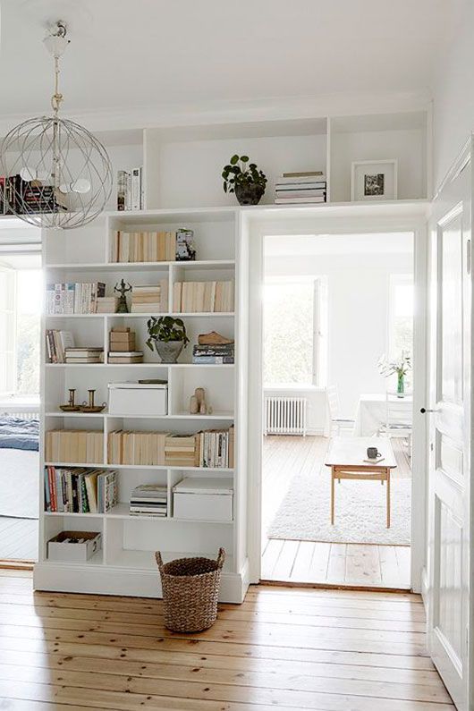 A white entryway with open cubbies and shelves above the doors is a cool idea to add more decor and storage space