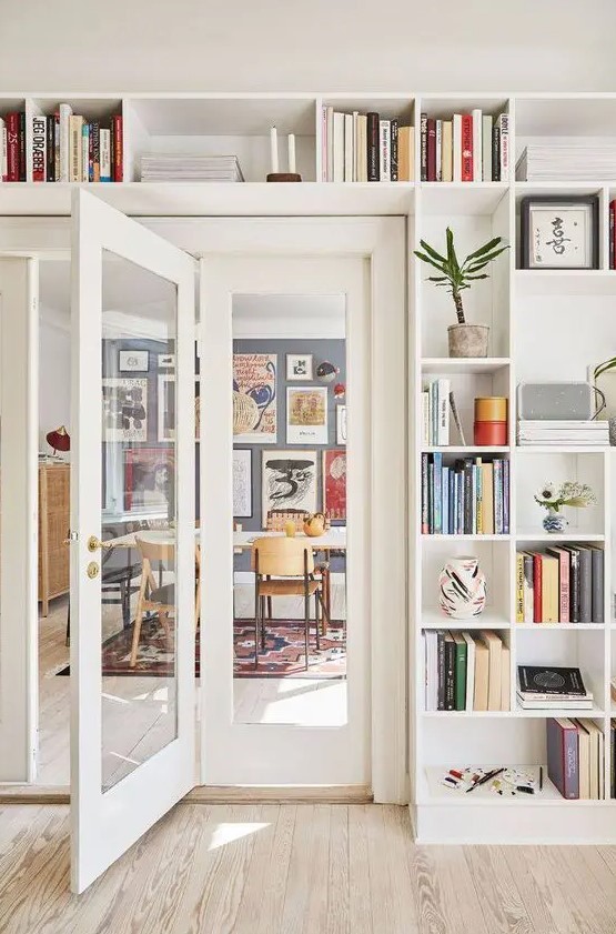 Open shelving surrounding the entryway and displaying books, potted plants, and artwork is a very cool idea to rock