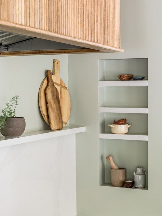 niche shelves used for storage and display in the kitchen look very sleek and seamless and allow you save some table space