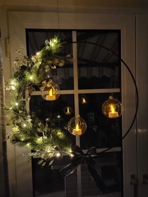 A beautiful holiday wreath with lights, evergreens, branches and hanging candle holders makes a cool Christmas decoration