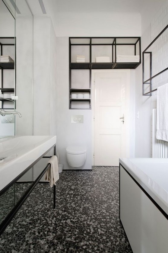 a bold contemporary bathroom in black and white, with a catchy terrazzo floor, black fixtures and framing is wow