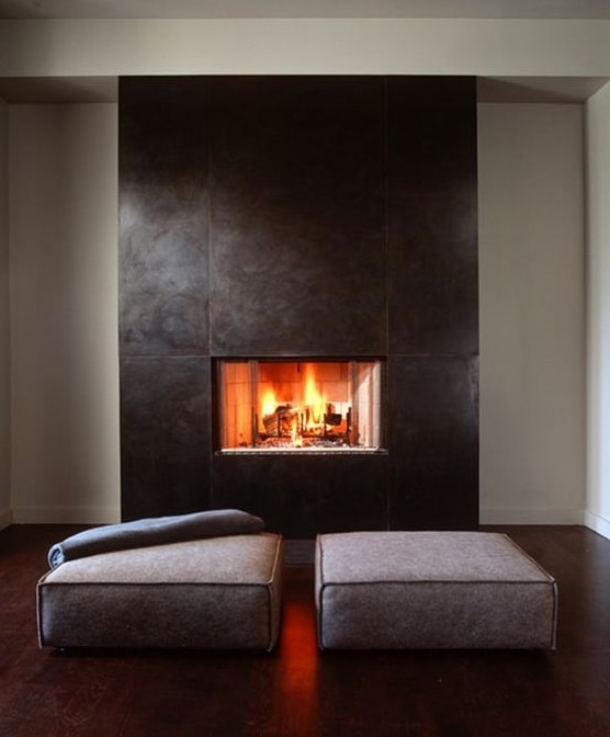 a clean and modern fireplace with sleek metal sheets that surround it and a couple of minimal cushions is a stylish idea