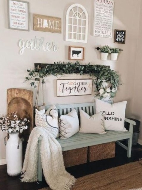 a farmhouse entry with a gallery wall, some greenery, a cotton arrangement, pillows on a mint bench and baskets