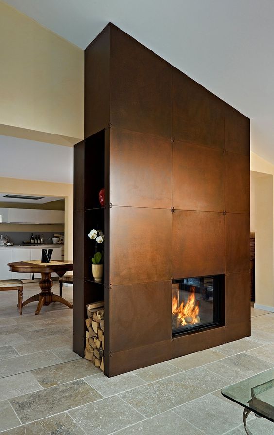 a fireplace clad with copper, with firewood storage and some blooms will become a focal point in the space