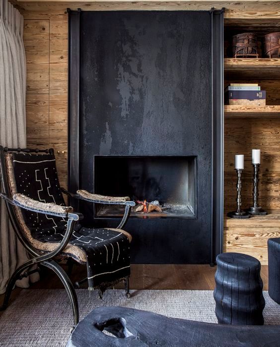 an exotic chalet living room with a metal fireplace, open shelves, a vintage and black side tables looks unique