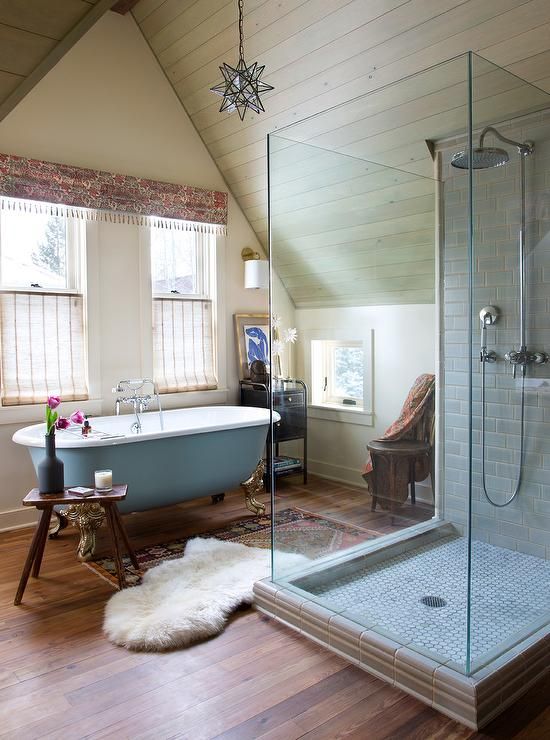 an opulent eclectic bathroom with touches of powder blue, a tiled shower, boho rugs and a boho printed curtain