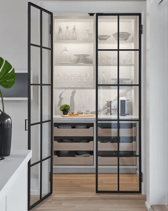 A stylish pantry with shelves, pull-out drawers and framed glass doors that allow you to see what's inside at all times