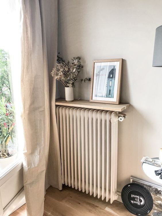 A neutral radiator that matches the wall and a matching shelf with decor is a nice way to make it almost invisible