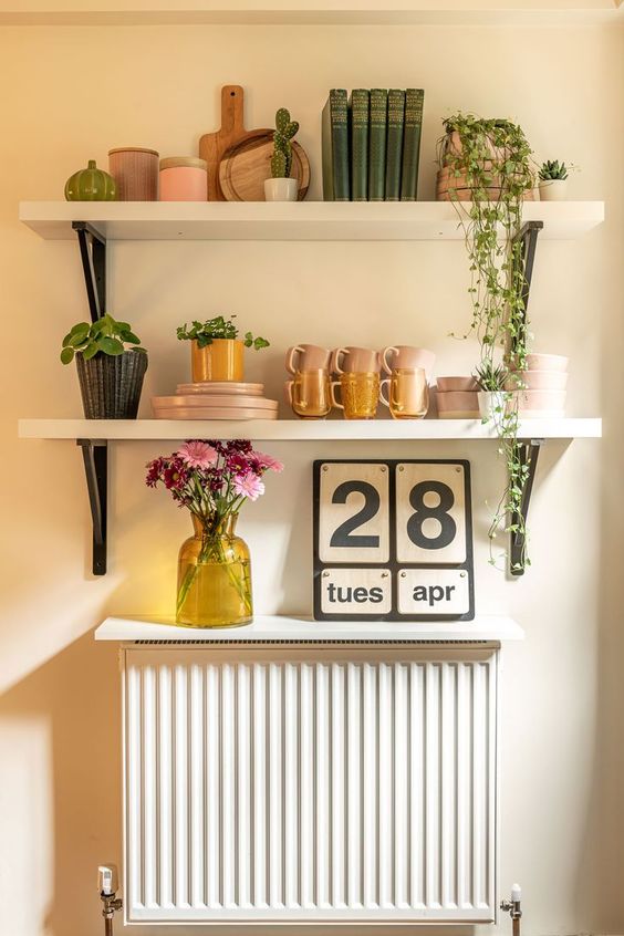 A small radiator with a small white shelf that matches the shelves above. In this way, the radiator becomes part of the furnishings