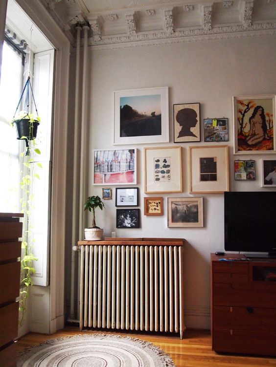 A small, stained shelf placed above the radiator blends harmoniously into the room and does not distract attention from the gallery wall