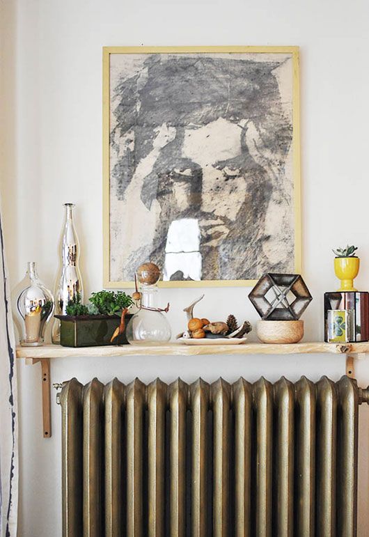 A small shelf above the radiator and many things displayed on this shelf are so conspicuous that no one sees the radiator itself