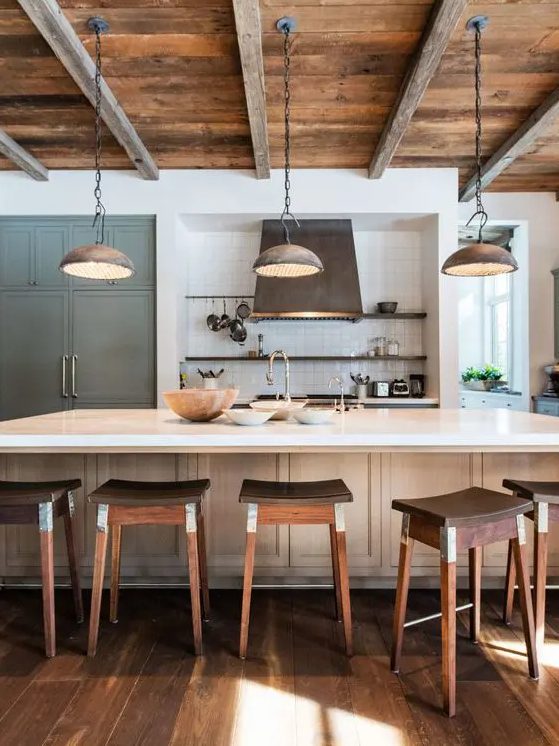 a rustic kitchen with bright stained cabinets, open shelving, built-in storage, richly stained stools and a reclaimed wood ceiling