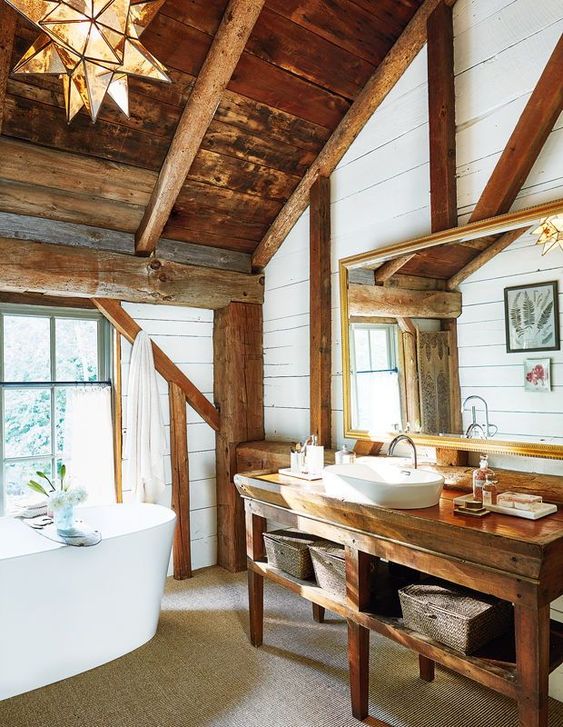 a rustic bathroom with a wooden roof and beams, a wooden vanity, an oval bathtub and an eye-catching star-shaped lamp