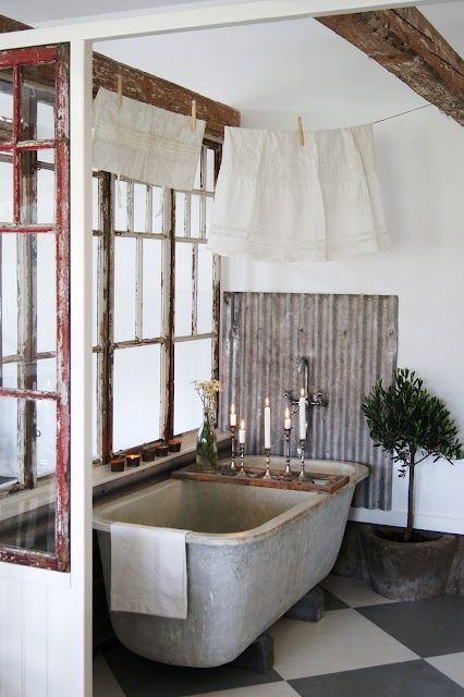 A shabby chic bathroom with a shabby chic frame and wooden beams, a concrete tub and corrugated iron, a potted tree is cool