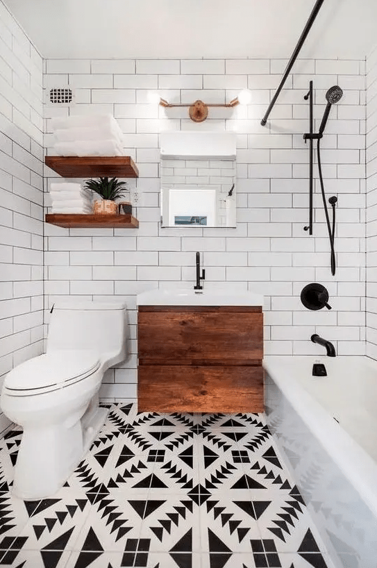 a small and chic modern bathroom with mosaic flooring, a floating wooden vanity, open shelves, a bathtub and white subway tiles