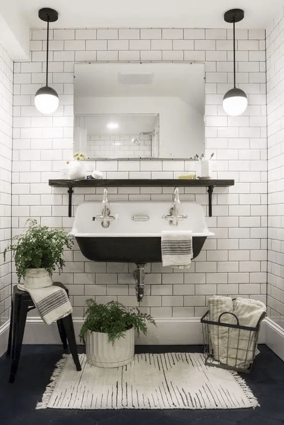 A vintage black and white powder room with white subway tiles and black grout